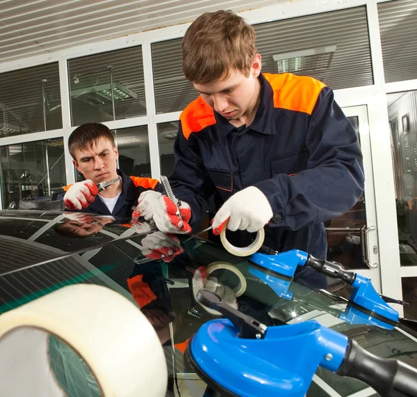 Dos mecánicos reales trabajando en taller de reparación de automóviles — Foto de Stock