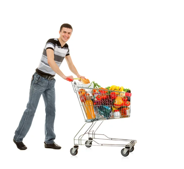 Junger Mann mit Einkaufswagen voller Lebensmittel — Stockfoto