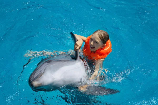 Mutlu küçük kız yunus yüzme havuzunda tesisi.
