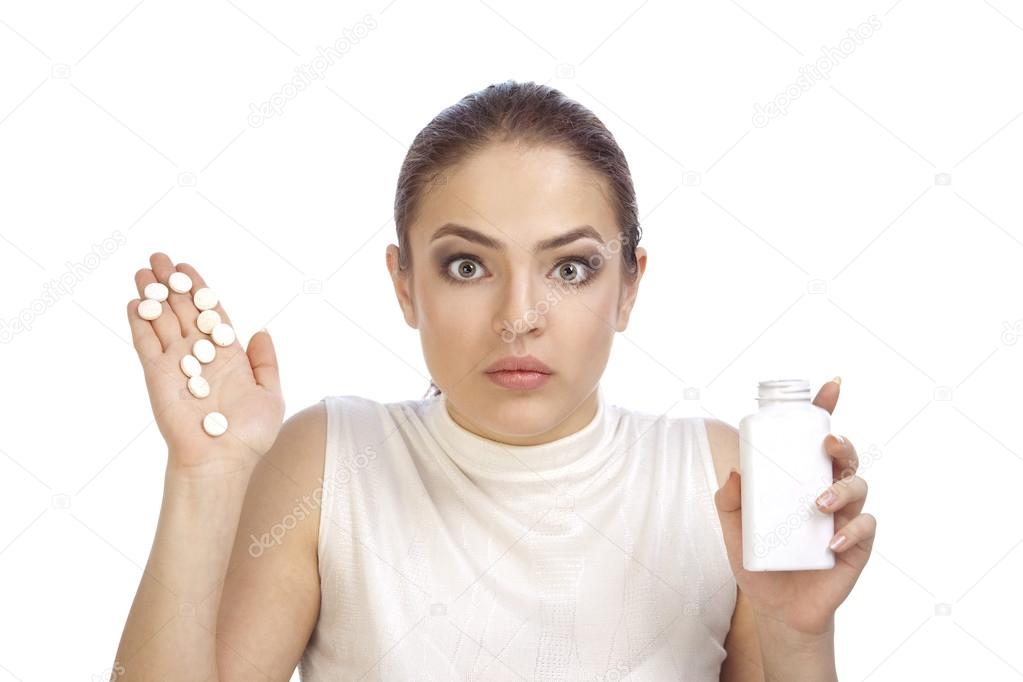 Young woman showing question mark made from pills