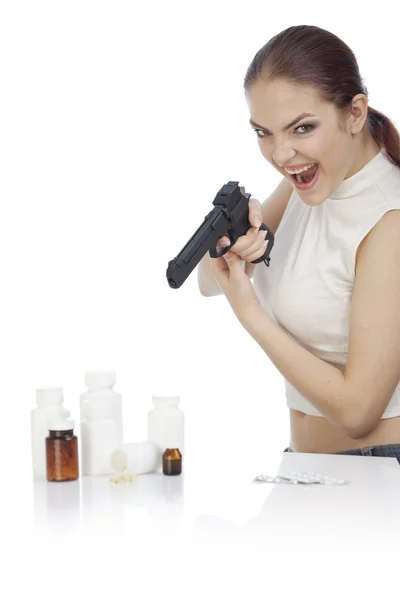 Молодая женщина, стреляющая в бутылки с таблетками — стоковое фото
