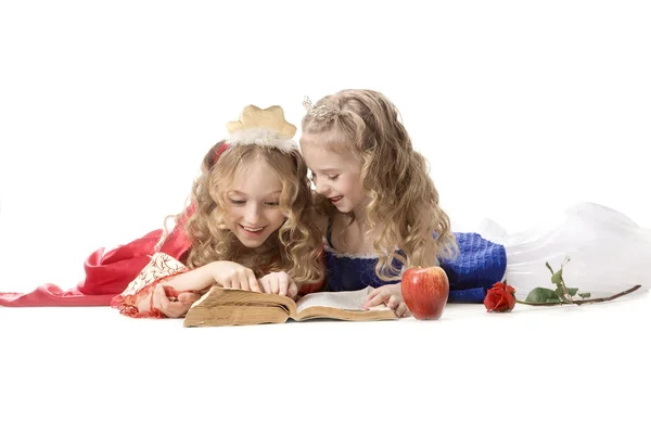 Deux joyeuses petites princesses lisant un livre magique — Photo