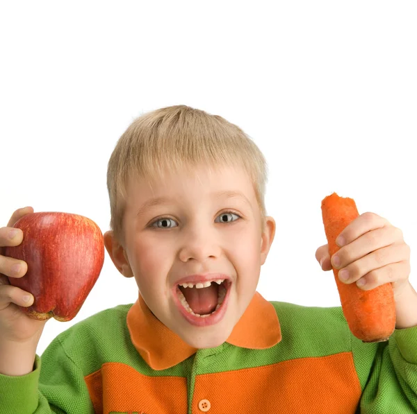 Menino feliz mordendo maçã e cenoura — Fotografia de Stock