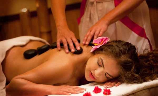 Gezonde Spa: Jonge mooie ontspannende vrouw met stenen Massage — Stockfoto