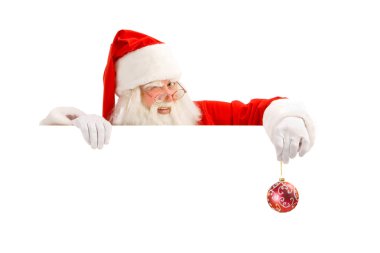 Bir işaret tutan klasik Noel Baba göz kırpıyor.