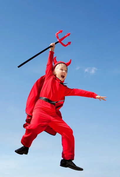 Дитина стрибає в диявола костюм і проведення тризуб — стокове фото