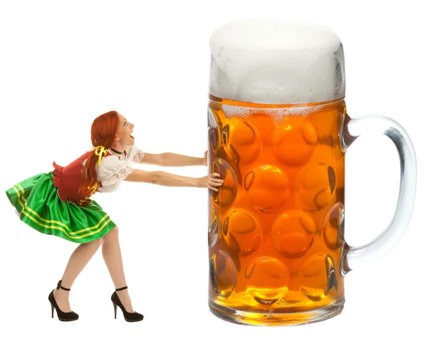 Счастливая женщина в традиционном костюме толкает огромный стакан пива — стоковое фото