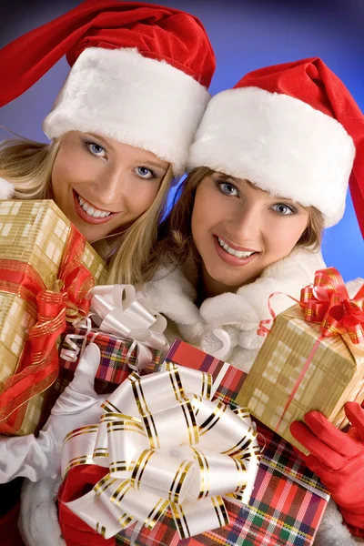 Dos chicas vestidas de Papá Noel se regocijan con regalos de Navidad — Foto de Stock