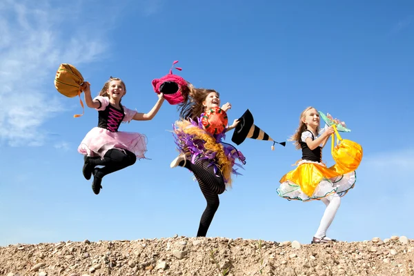 Three Cute Little Witches Jumping with Bags — Stockfoto