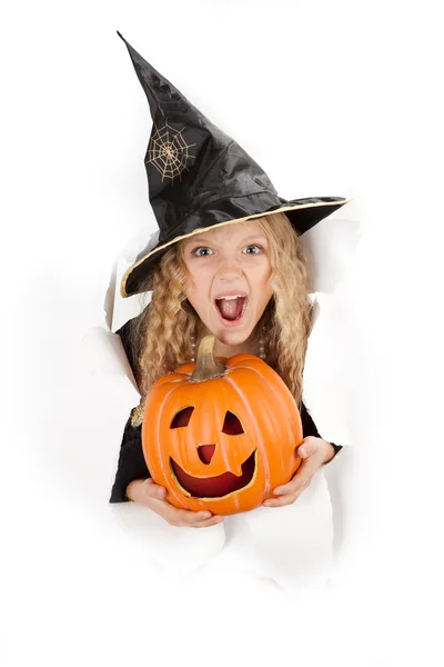 Little witch peeking through a hole in white paper Royalty Free Stock Images