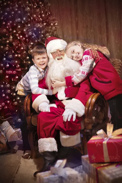 Guiño clásico de Santa sentado con niños felices —  Fotos de Stock