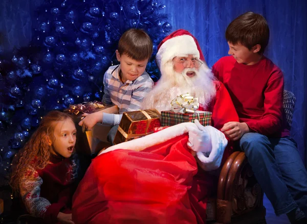 Clásico Santa dando regalos de Navidad a niños felices . —  Fotos de Stock