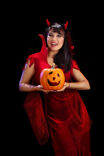 Frau in Halloween-Kostümen von Teufeln, die einen Kürbis in der Hand halten — Stockfoto