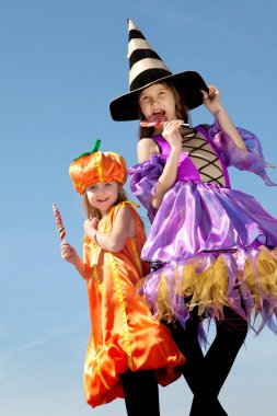 İki mutlu küçük Halloween kız şekerleme yalama.