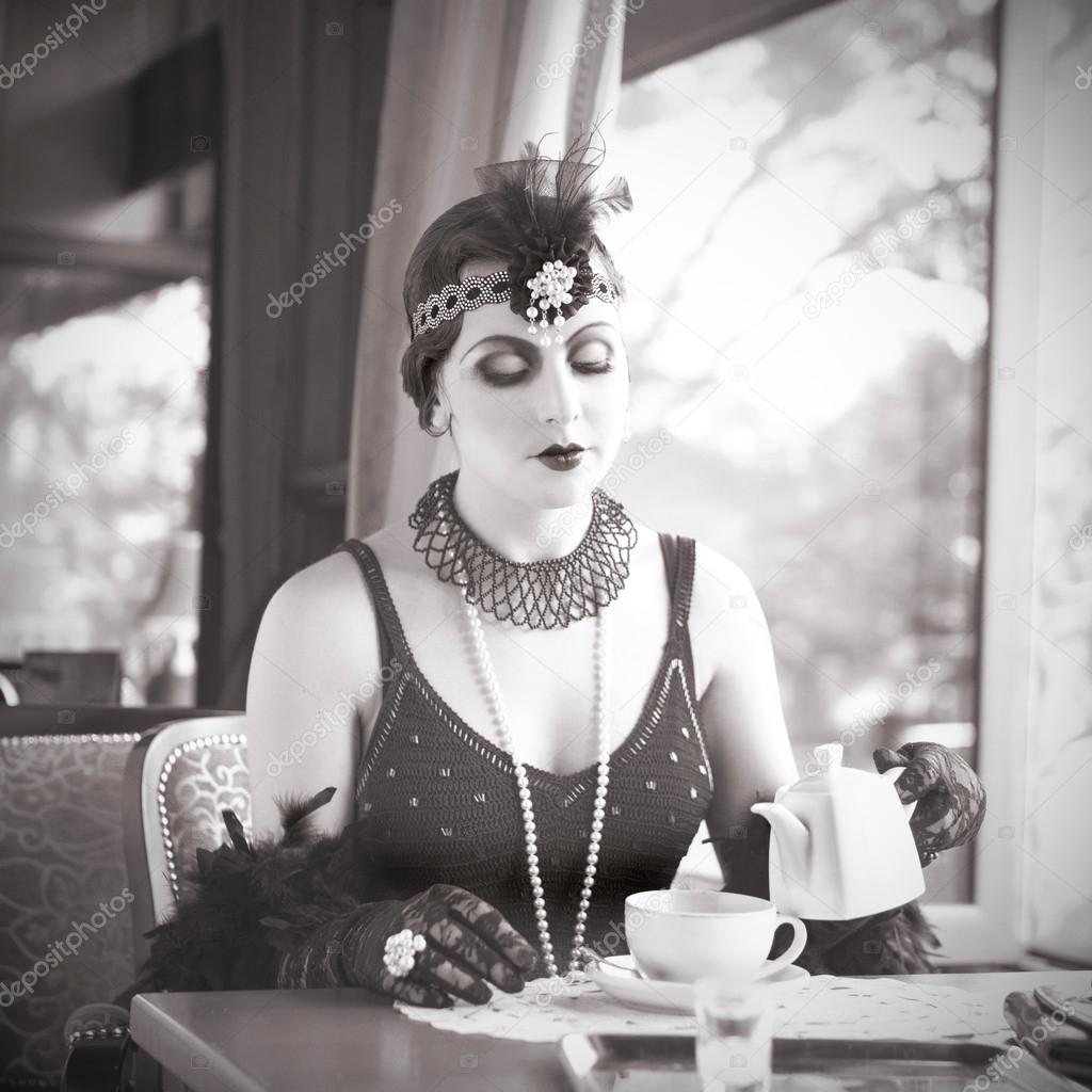 Retro Woman 1920s - 1930s Sitting with in a Restaurant Holding a