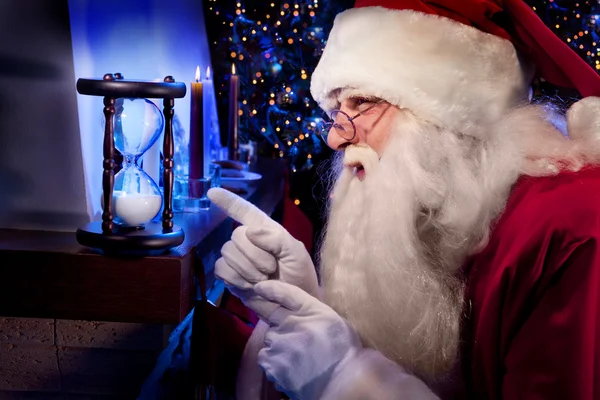 Santa Claus op zoek naar het zand glas — Stockfoto