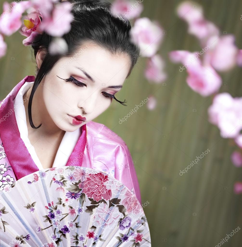 Young Woman Wearing Kimono Dress at the Bamboo Backgruond