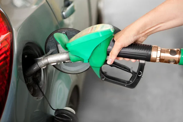 Un brazo repostando el coche en una gasolinera —  Fotos de Stock