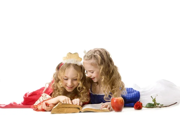 Deux joyeuses petites princesses lisant un livre magique — Photo