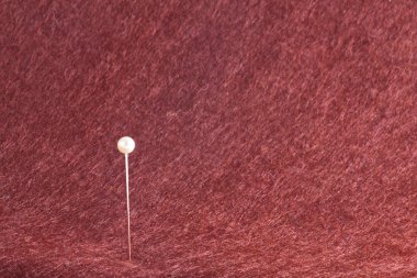 İğne ile yapılan keçe kırmızı rengini arka plan üzerinde sıkışmış bir beyaz top