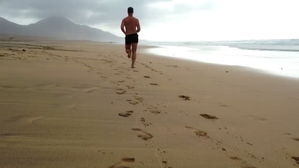 Man jogging on the beach — Stock Video