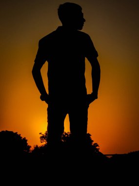Siyah insan silueti, insanoğlu güneşin doğuşuna bakıyor ve huzuru hissediyor..