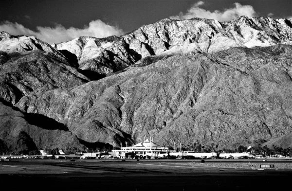 Palm Springs Airport at Sunrise in Coachella Valley with Snow on Mount San Jacinto, an 11,000 foot tall Granite Massif jutting straight up from the Desert Floor in the city of Palm Springs, California, U.S.A.  In black and white film.