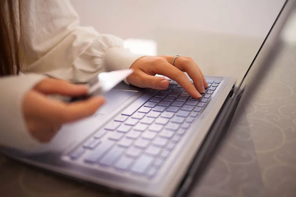 Evde bilgisayarla çalışan mutlu ve serbest bir genç kadın. İnternette okuyan çekici bir iş kadını, dizüstü bilgisayar, internet sörfü bilgisi veya internet mağazasından alışveriş yapıyor. Genç kahverengi saçlı kadın online alışveriş yapıyor..
