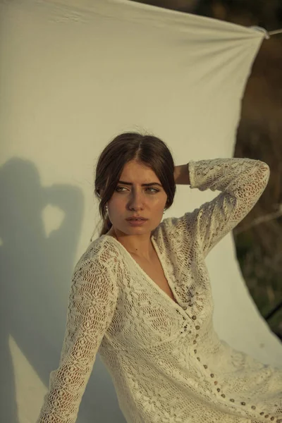 Beyaz arka planda ve doğada beyaz elbiseli bir kadının portresi. Bir buket çiçek tutan manken. Beyaz arkaplanda bir modelin portresi