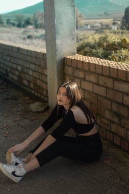 Sokaktaki genç kadının portresi. Mavi gözlü kadın. Gençlik modası. Şehir tarzı. İnşaat halindeki bir binada kadın.