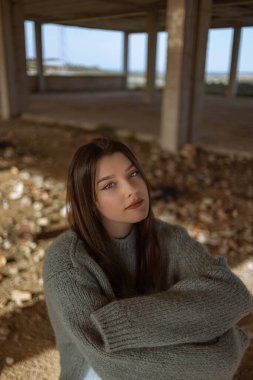 Sokaktaki genç kadının portresi. Mavi gözlü kadın. Gençlik modası. Şehir tarzı. İnşaat halindeki bir binada kadın.