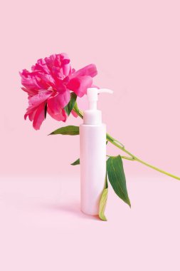 Pembe pastel arka planda pembe şakayık çiçekleri olan bir kozmetik şişesi. Kozmetik posteri ya da afiş tasarımı. Taze, modern duvar kağıdı. Reklam afişi. Yine de hayat reklamı. Yüksek kalite fotoğraf