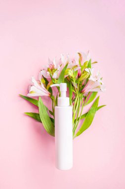 Pembe arka planda buket çiçekli kozmetik şişesi. Magazin sayfası tarzı. Kozmetik posteri ya da afiş tasarımı. Taze, modern duvar kağıdı. Reklam afişi. Yine de hayat reklamı. Yüksek kalite fotoğraf