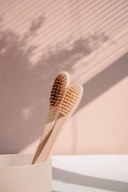 Pastel arka planda çiçek gölgeli sıfır atık bambu diş fırçası. Yüksek kalite fotoğraf