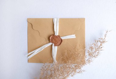 Kartvizitli el işi zarfı beyaz arka planda süslü wtih pampas çimlerini taklit ediyor. Yüksek kalite fotoğraf