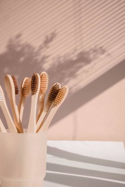 Pastel arka planda çiçek gölgeli sıfır atık bambu diş fırçası. Yüksek kalite fotoğraf