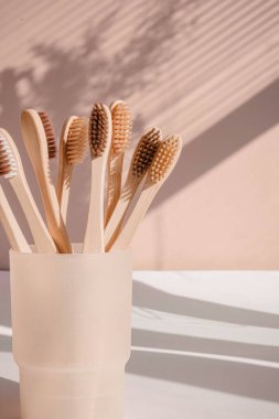 Pastel arka planda çiçek gölgeli sıfır atık bambu diş fırçası. Yüksek kalite fotoğraf