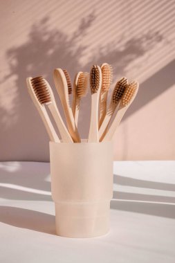 Pastel arka planda çiçek gölgeli sıfır atık bambu diş fırçası 