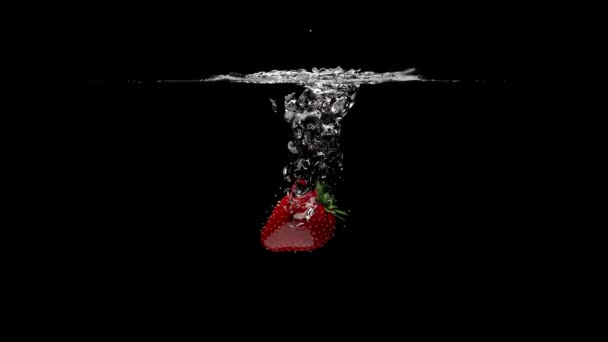 Las fresas caen en agua clara. Fondo negro. Representación en 3D. — Vídeo de stock