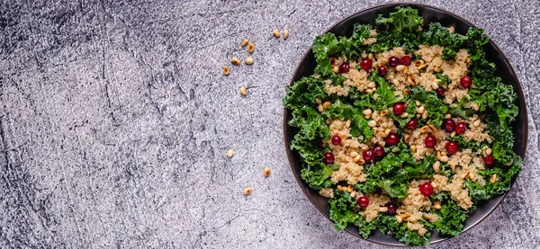 Healthy raw kale and quinoa salad with cranberry and pine nut. Top view.