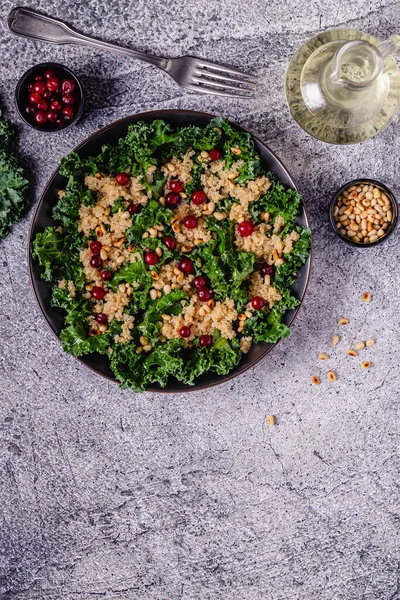 Healthy raw kale and quinoa salad with cranberry and pine nut. Top view.