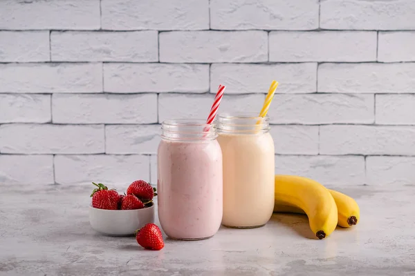 Strawberry and banana milkshakes in the glass jars