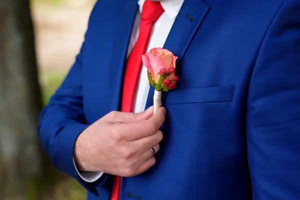 Een knoopsgat bezit het pak van de verloofde een hand — Stockfoto