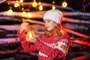 Kız model elinde Noel ağacı oyuncağı tutuyor.