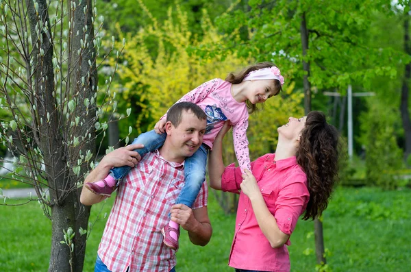 Familia feliz juega una parka con un niño —  Fotos de Stock