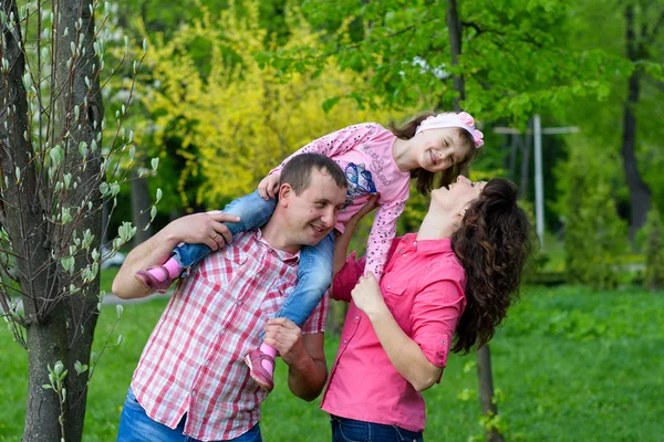 Família feliz joga uma parka com uma criança — Fotografia de Stock