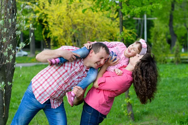 Família feliz joga uma parka com uma criança — Fotografia de Stock