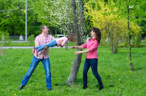 Família feliz joga uma parka com uma criança — Fotografia de Stock