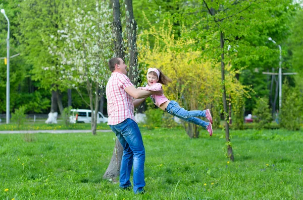 Happy family plays a parka with a child — Stock Photo, Image