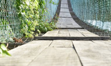 Asma köprü yeşil çalılarla dolu ve zincirli tel örgülerden yapılma Penampang, Borneo, Sabah, Malezya kırsalında yol için kontraplaktan yapılmış.. 